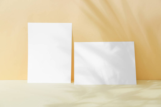 Two blank sheets of paper with shadow on color background - Foto, imagen