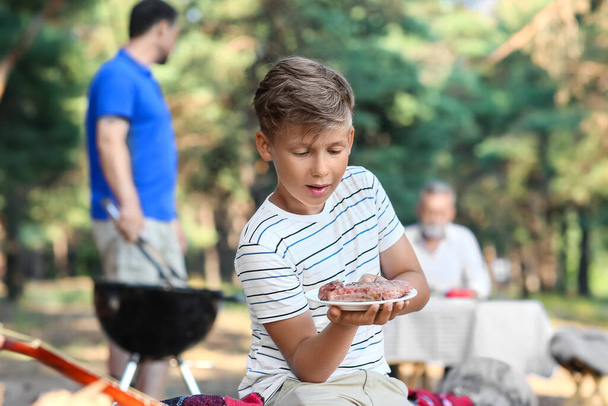 Kleiner Junge hält Teller mit Grillfleisch bei Grillparty - Foto, Bild