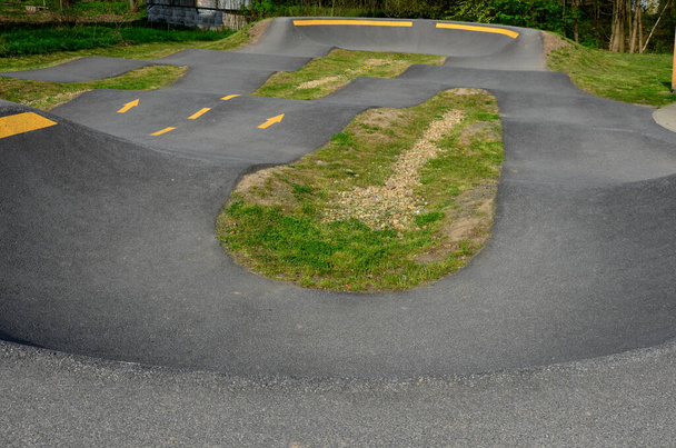 ciclovia no parque de estacionamento Bombeamento (movendo-se para cima e para baixo) é usado em vez de pedalar e saltar para mover bicicletas, scooters, skates e patins inline ao longo da pista de bombeamento modular - Foto, Imagem