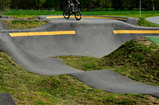 bike path in the car park Pumping (moving up and down) is used instead of pedaling and bouncing to move bicycles, scooters, skateboards and inline skates along the modular pumptrack track - Photo, Image