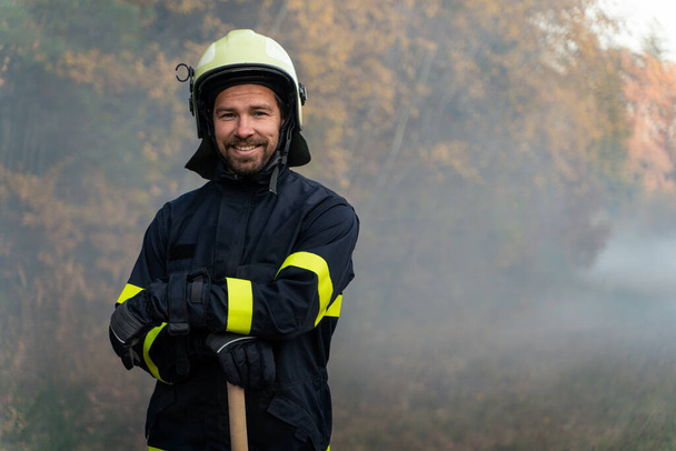 Portrait of happy firefighter man looking at camera after successful action in forest - Φωτογραφία, εικόνα
