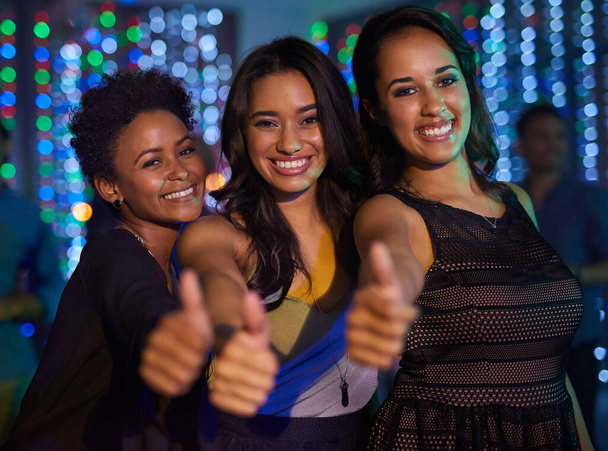 Bons tempos no clube. Retrato de um grupo de jovens senhoras mostrando polegares para cima enquanto se diverte em um clube. - Foto, Imagem