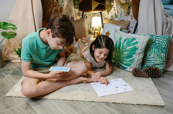 Children playing in a cozy diy tent at home - Photo, image