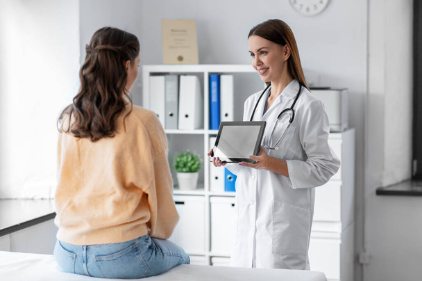 female doctor shows tablet pc to woman at hospital - Valokuva, kuva
