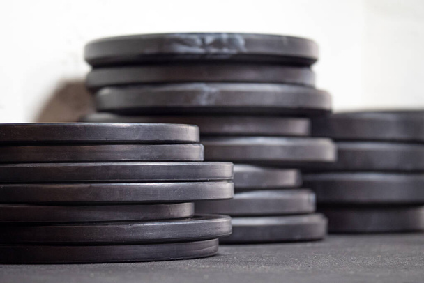 Imagen de las placas de pesaje del gimnasio negro en el suelo - Foto, imagen