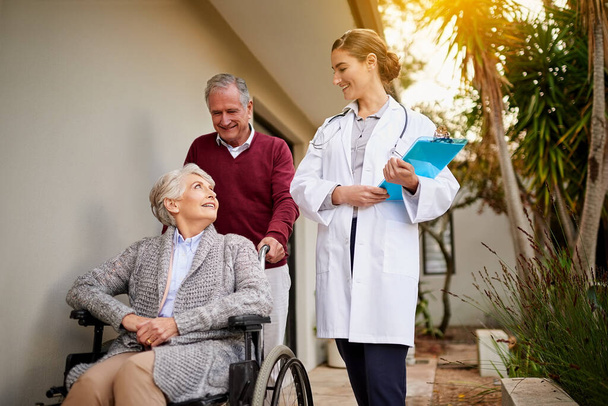 Nothing makes her happier than discharging a healthy patient. Shot of a senior couple and a nurse outside a nursing home. - Photo, Image