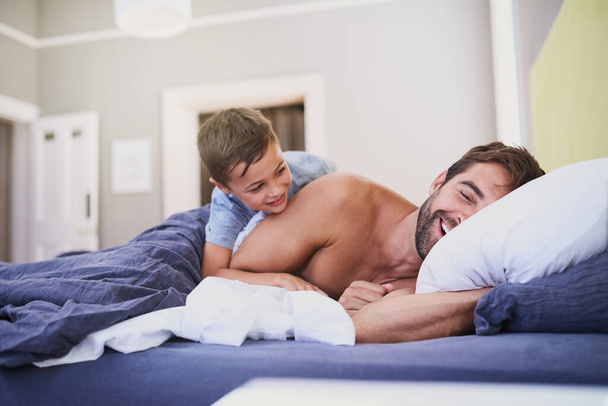 Wake up, dad. Cropped shot of a handsome young man being woken up by his son. - Fotoğraf, Görsel