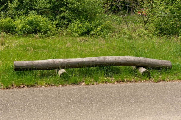 Nature bench made from a wooden trunk in the meadow - Photo, Image