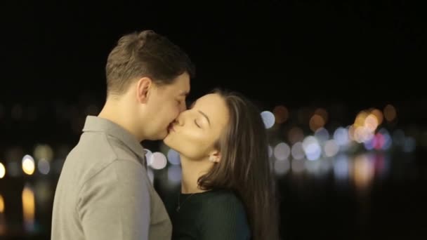 A sweet couple lovers kisses behind the citys lights. Valentines young couple on Valentines day - Materiał filmowy, wideo