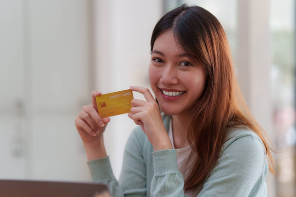 Vrouw die online betaling gebruikt en een creditcard heeft. Online winkelen concept. - Foto, afbeelding