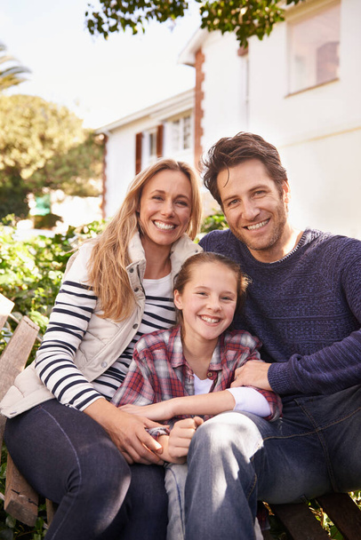 Οικογενειακός χρόνος στο σπίτι. Ένα πορτραίτο μιας ευτυχισμένης οικογένειας που ποζάρει έξω από το σπίτι. - Φωτογραφία, εικόνα