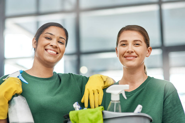 Onze reputatie is net zo vlekkeloos als uw kantoor. Portret van twee jonge vrouwen die een modern kantoor schoonmaken. - Foto, afbeelding