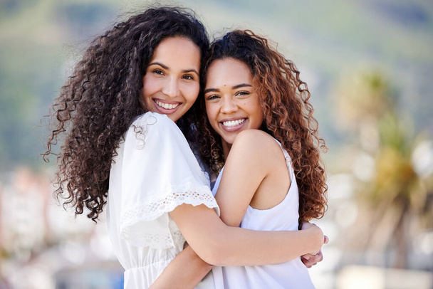 Because of her I smile a whole lot more. Shot of two young women hugging outdoors. - Foto, Imagen