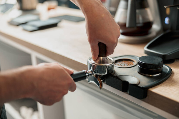 Primer plano de barista tamping café molido para hacer espresso - Foto, imagen