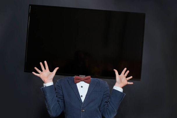 Funny kid boy with modern tv head on black background - Photo, Image