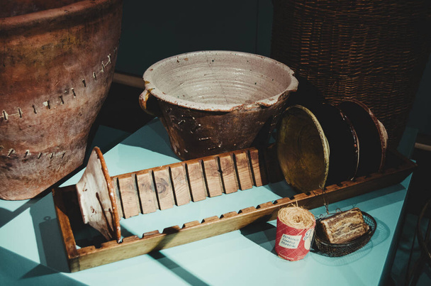 antico essiccatore in legno con piatti in terracotta e pentole su tavola blu - Foto, immagini