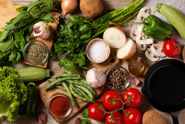Zöldségek, fűszerek és fűszerek választéka fából készült asztalon - Fotó, kép