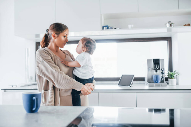 Female blogger mother with her kid together indoors at home at weekend. - Φωτογραφία, εικόνα