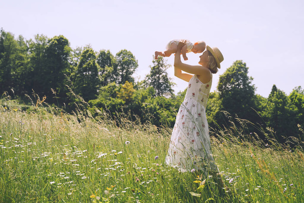 Mutter und Baby. Konzept der natürlichen Mutterschaft und Mutterschaft. Schöne Frau und kleines Baby glücklich zusammen in der grünen Natur Hintergrund. Liebevolle Mutter mit Kind im Freien. - Foto, Bild