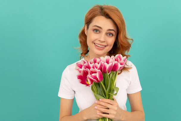 happy woman with tulip flower bouquet on blue background. spring - Foto, afbeelding