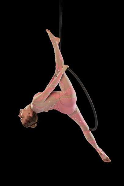 Genç, esnek bir kızın portresi, profesyonel hava jimnastikçisi, siyah stüdyo arka planında izole edilmiş eğitim. - Fotoğraf, Görsel