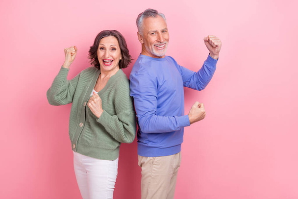 Portrait of two excited crazy partners raise fists triumph delighted isolated on pink color background - Fotoğraf, Görsel