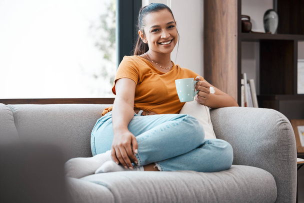 Bir fincan sıcak kahveden daha iyi bir şey yoktur. Evdeki kanepede dinlenen genç bir kadının fotoğrafı.. - Fotoğraf, Görsel