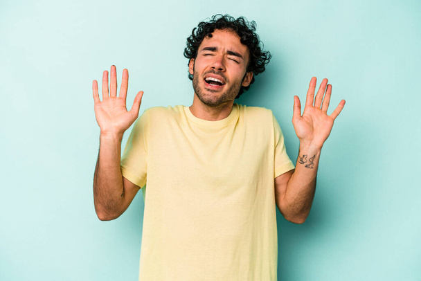 Young caucasian man isolated on white background screaming to the sky, looking up, frustrated. - 写真・画像