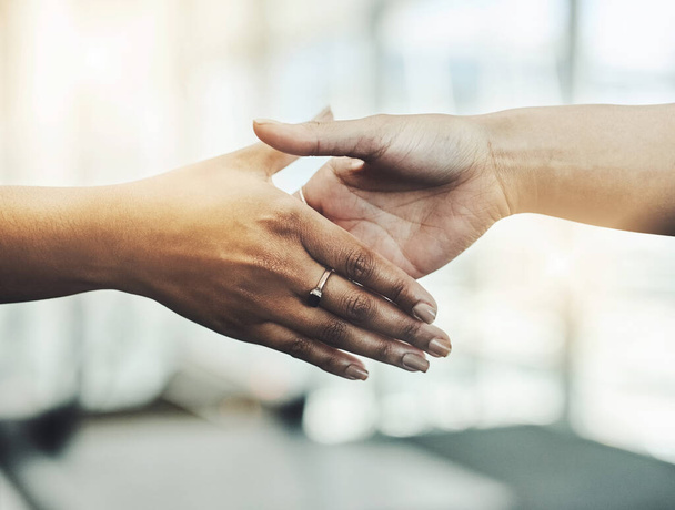 Shake to the agreement. Closeup shot of two unrecognizable businesswomen shaking hands while standing in a modern workplace. - Foto, imagen