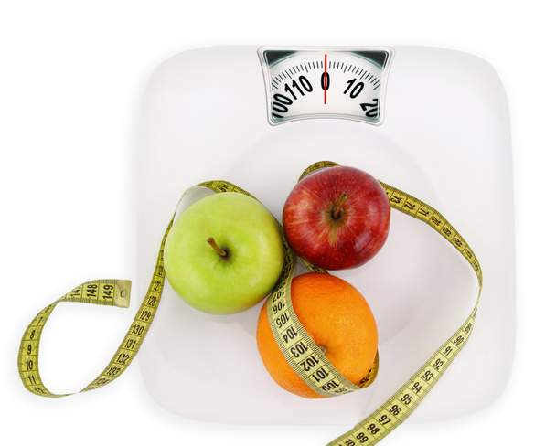 Concepto de dieta. Frutas con cinta métrica en un plato como el peso
 - Foto, imagen