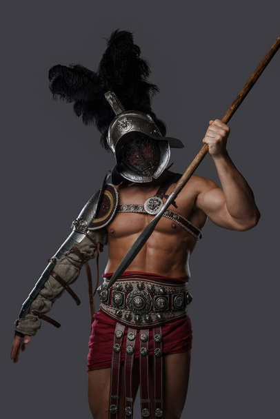 Gladiatoren-Speerwerfer werfen Speer vor grauem Hintergrund - Foto, Bild