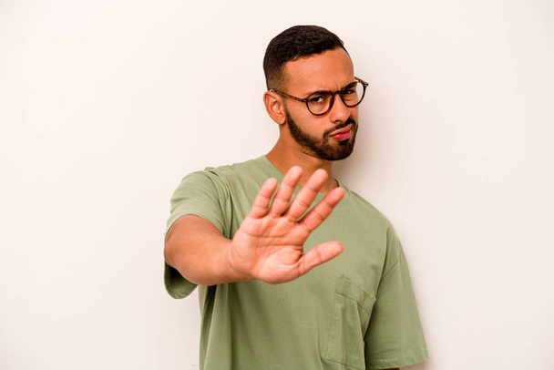Young hispanic man isolated on white background rejecting someone showing a gesture of disgust. - Photo, Image