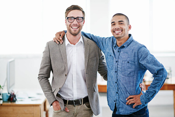 Partner with someone who wants you to succeed. Shot of two businessmen standing together in an office. - Foto, imagen