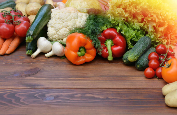Sada zeleniny na dřevěném pozadí: mrkev, brambory, cuketa, paprika, okurka, česnek, rajčata, salát. Zdravé jídlo koncepce se zeleninou a přísady pro vaření. Horní pohled.Kopírovat mezeru - Fotografie, Obrázek