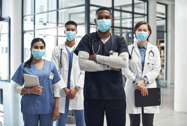 E 'importante tenersi protetti. Girato di un gruppo di medici e infermieri che indossano maschere facciali per proteggere dalla malattia. - Foto, immagini
