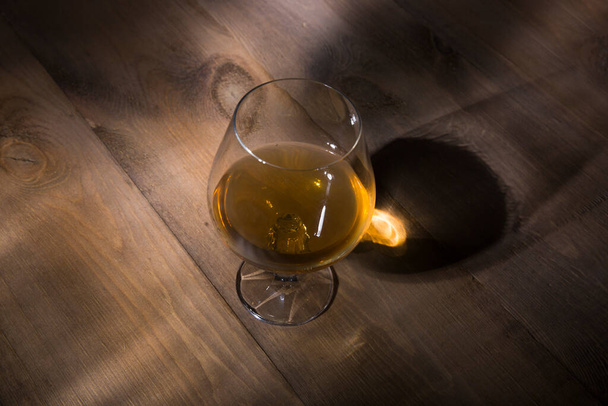 Glass of brandy or cognac on the wooden table - Fotó, kép