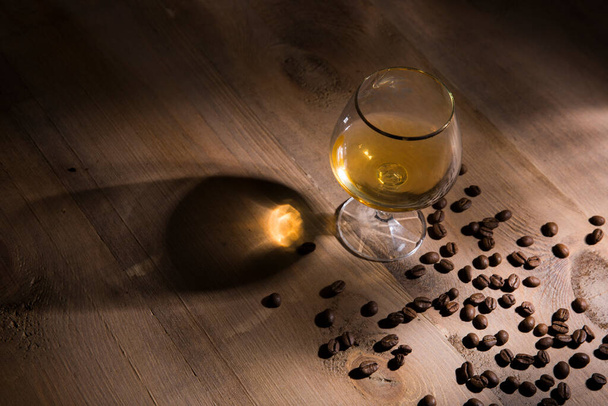 A glass of brandy on a wooden background - Foto, Imagen