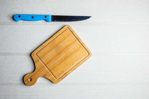 Tabla de cortar y un cuchillo en la mesa - Foto, Imagen