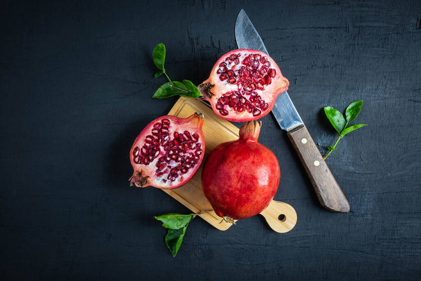pomegranate fruit sliced on a black background - Photo, Image