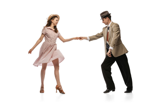 Young man and woman in vintage retro style outfits dancing social dance isolated on white background. Timeless traditions, 1960s american fashion style and art - Фото, изображение