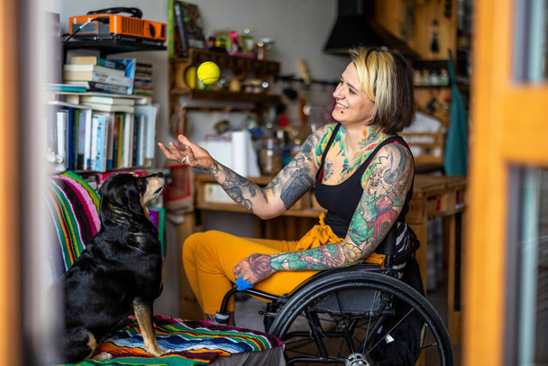 Young woman with disability with her dog at home - 写真・画像