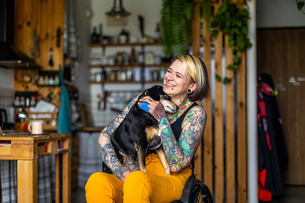Young woman with disability with her dog at home - Foto, afbeelding