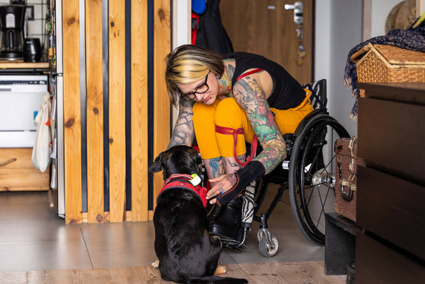 Young woman with disability with her dog at home - Valokuva, kuva