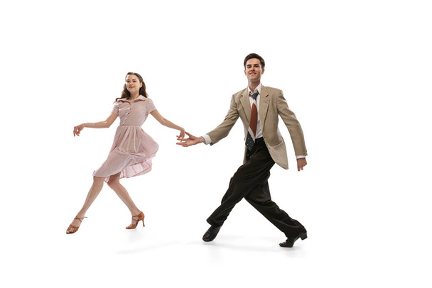Young man and woman in vintage retro style outfits dancing social dance isolated on white background. Timeless traditions, 1960s american fashion style and art - Valokuva, kuva