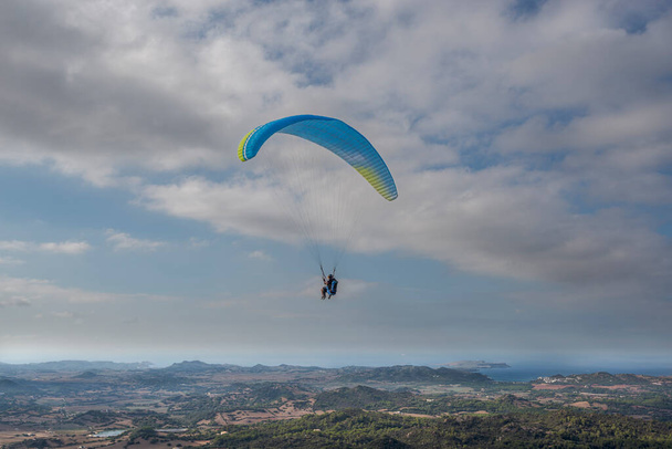 Πρώτη πτήση με διπλό εκπαιδευτή αλεξίπτωτου πλαγιάς. Φωτογραφία από το σημείο επιφυλακής El Toro, δήμος Es Mercadal, Menorca, Ισπανία - Φωτογραφία, εικόνα
