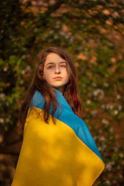 Tyttö seisoo Ukrainan lipun kanssa. Keltainen ja sininen kangas. - Valokuva, kuva