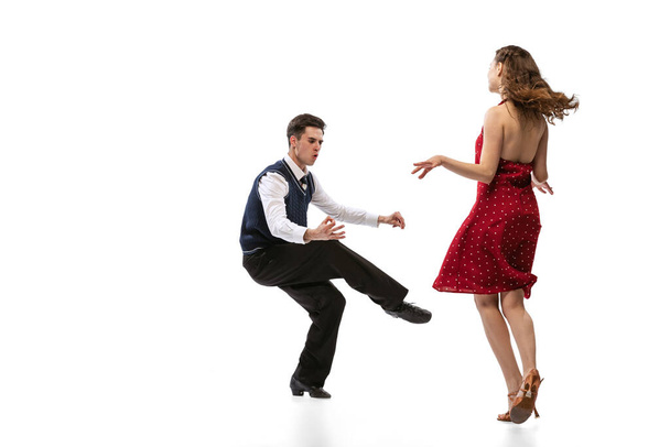 Quickstep. Beautiful girl and stylish man in vintage retro style outfits dancing isolated on white background. Timeless traditions, 60s,70s american fashion style and art - Φωτογραφία, εικόνα