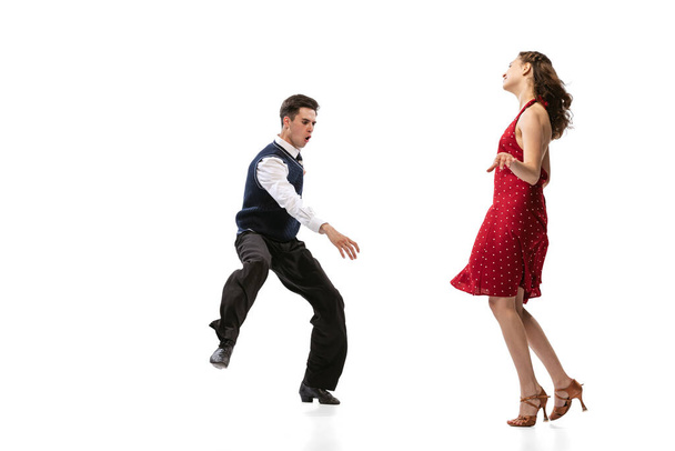Beautiful girl and stylish man in vintage retro style outfits dancing isolated on white background. Timeless traditions, 60s,70s american fashion style and art - Fotoğraf, Görsel