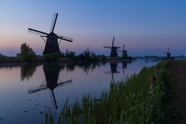 Mulini a vento tradizionali olandesi con un cielo colorato poco prima dell'alba a Kinderdijk, Paesi Bassi - Foto, immagini