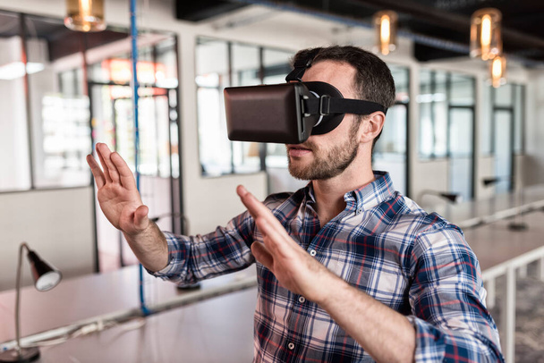 Man using virtual reality glasses in startup office. - Fotó, kép